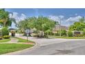 Community entrance with manicured landscaping, signage, and a security gate at 186 Viola Dr, Auburndale, FL 33823
