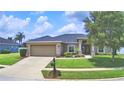 Charming single-story home featuring a manicured lawn, stone accents, and a two-car garage at 186 Viola Dr, Auburndale, FL 33823