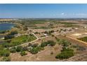 Wide aerial view of property with multiple small lakes nearby and light vegetation and clear blue skies at 2390 Lake Easy Rd, Babson Park, FL 33827
