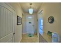 Bright entryway with a white door, decorative items, and a glimpse into the bedroom at 2577 Canyon Crest Dr, Lakeland, FL 33811