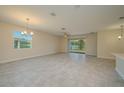 Open-concept living room featuring tile floors, a ceiling fan, and sliding glass doors at 2733 Attwater Loop, Winter Haven, FL 33884