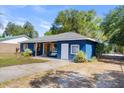 Cozy blue home showcasing a welcoming porch, bench, and a well-manicured lawn at 275 Cherry Laurel Ln, Winter Haven, FL 33880