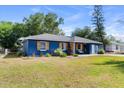 Quaint blue home with wood shutters, front bench, and freshly cut green grass at 275 Cherry Laurel Ln, Winter Haven, FL 33880