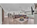 Spacious open-concept living room with wood floors, barn door, fireplace, and a large leather couch at 317 Oak Trl, Lakeland, FL 33813