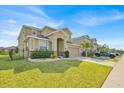 Lovely two-story home with a well-maintained lawn and landscaped garden beds at 3853 Cortland Dr, Davenport, FL 33837