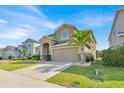Beautiful two-story home with well-kept lawn and a two-car garage, complemented by lush landscaping at 3853 Cortland Dr, Davenport, FL 33837
