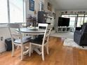 Charming dining area with wood floors and a table set for four, next to the living room and fireplace at 4007 Cypress Lndg S, Winter Haven, FL 33884