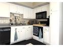Well-maintained kitchen featuring white cabinets, neutral countertops and modern appliances at 4007 Cypress Lndg S, Winter Haven, FL 33884