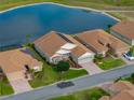 Aerial shot of a home with lake view, well-kept lawn, and solar panels on the roof at 4081 Dunmore Dr, Lake Wales, FL 33859