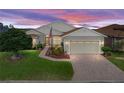 Attractive one-story home with a brick driveway, well-maintained landscaping, and a tranquil sky at 4081 Dunmore Dr, Lake Wales, FL 33859