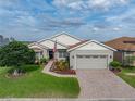 Charming single-story home featuring a brick driveway, lush lawn, and vibrant flowerbeds at 4081 Dunmore Dr, Lake Wales, FL 33859
