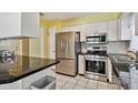 Eat-in kitchen with stainless steel appliances, white cabinets, and black countertop at 419 Broward Ter, Winter Haven, FL 33884