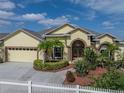 Beautiful home featuring a well-manicured lawn, a charming white picket fence, and a spacious driveway leading to a garage at 428 Terranova St, Winter Haven, FL 33884