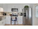 Modern kitchen featuring stainless steel appliances, white cabinetry, and stylish backsplash, designed for culinary enthusiasts at 4940 Foxdale Dr, Lakeland, FL 33810