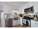 Well-lit kitchen featuring stainless steel appliances, white cabinets, a farmhouse sink, and modern fixtures at 4940 Foxdale Dr, Lakeland, FL 33810