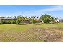 Spacious backyard featuring lush green grass and mature trees, great for outdoor activities at 501 Main St, Lake Hamilton, FL 33851