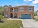 Inviting two-story home with a well-maintained lawn, blue garage, and front porch seating at 524 Nogales, Kissimmee, FL 34758
