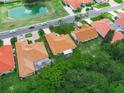 Birds-eye view displaying the home's tile roof, backyard with screened pool, and nearby pond at 530 Greenway Dr, Lake Wales, FL 33898