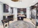Spacious kitchen boasting dark wood cabinets, stainless steel appliances, and a central island at 5787 Dornich Dr, Auburndale, FL 33823
