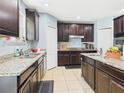 Well-equipped kitchen showcasing granite countertops and dark cabinets at 5787 Dornich Dr, Auburndale, FL 33823