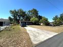 Single-story home featuring a spacious driveway and trees at 620 Se Oleander Se Dr, Winter Haven, FL 33880