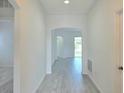 Bright entryway featuring light gray wood floors, white walls, and an arched doorway at 625 Disa Dr, Davenport, FL 33837