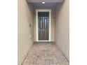 Front entryway shows a well-lit, brick walkway leading to a dark, paneled front door with white trim at 625 Disa Dr, Davenport, FL 33837