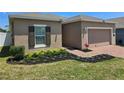 Beautifully landscaped front yard features a brick driveway and walkway leading to the front door at 625 Disa Dr, Davenport, FL 33837