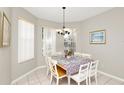 Cozy dining room featuring tile floors, natural light from large windows, and a decorative chandelier above the table at 662 Orista Dr, Davenport, FL 33897