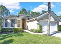 Charming single-story home featuring a 2-car garage, landscaped yard and a walkway leading to the front door at 662 Orista Dr, Davenport, FL 33897