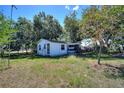 Cute single story home with mature trees, a screened porch, and a front lawn at 6925 3Rd St, Mulberry, FL 33860