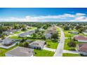 Neighborhood aerial view, homes with pools, lush green lawns, mature trees, and clear blue skies at 716 Maderia Ct, Kissimmee, FL 34758