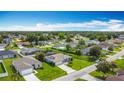 Neighborhood aerial view featuring neatly arranged homes, green lawns, and tree-lined streets in a peaceful setting at 716 Maderia Ct, Kissimmee, FL 34758