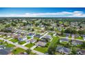 Expansive aerial shot showcasing a residential neighborhood with well-maintained homes and lush greenery at 716 Maderia Ct, Kissimmee, FL 34758