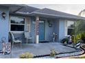 Inviting front porch with decor, seating, and a turquoise front door at 716 Maderia Ct, Kissimmee, FL 34758