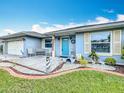 Single-story home showcasing a well-kept lawn, inviting front porch with chairs, and charming landscaping at 716 Maderia Ct, Kissimmee, FL 34758