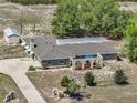 Aerial view of the single-story home featuring a covered patio with blue umbrella and ample outdoor space at 9019 Oakwood Dr, Lake Wales, FL 33898