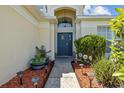 Inviting entrance with a blue front door, tidy landscaping, and pathway lighting for added curb appeal at 936 Lake Berkley Dr, Kissimmee, FL 34746
