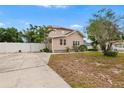 Charming home featuring a spacious driveway, manicured lawn, and a white privacy fence at 102 Deen Blvd, Auburndale, FL 33823