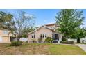 Charming home with light siding, manicured lawn, and a welcoming front entrance featuring a covered porch at 102 Deen Blvd, Auburndale, FL 33823