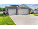 Well-maintained home showcasing a spacious driveway leading to a three-car garage with stone accents at 1045 Montgomery Ln, Polk City, FL 33868