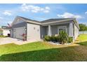 This house has a three-car garage, pristine landscaping with decorative accents, and a well-maintained lawn at 1045 Montgomery Ln, Polk City, FL 33868