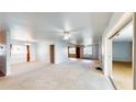 Bright living room featuring carpet flooring, ceiling fan, and open layout, with windows providing natural light at 108 Lake Howard Dr Nw, Winter Haven, FL 33880