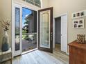 An open foyer featuring a decorative glass front door and sidelights, with tile floors and views to the exterior at 1104 Sawgrass Dr, Winter Haven, FL 33884