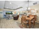 Open living space with tile floors, a tray ceiling, comfortable seating, and seamless access to the kitchen and dining areas at 1104 Sawgrass Dr, Winter Haven, FL 33884