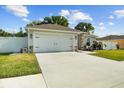 View of the home's exterior showcasing the driveway, garage, and fenced yard at 1221 Alameda S Dr, Lakeland, FL 33805