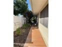 A well kept side yard featuring a wooden walkway, mature foliage, and a white privacy fence at 124 Palm Pl, Haines City, FL 33844