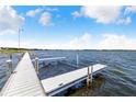 Scenic view of a wooden dock extending into a calm lake under a clear blue sky at 151 Winter Ridge Dr # 151, Winter Haven, FL 33881