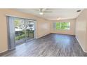 Bright living room featuring sliding doors to the balcony and wood-look flooring at 1550 11Th Ne St # E7, Winter Haven, FL 33881