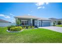 Inviting single-story home with vibrant green lawn, decorative landscaping, and a serene residential setting on a sunny day at 157 Walkers Point Dr, Auburndale, FL 33823